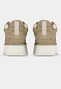 Μπεζ αθλητικά παπούτσια με υφή σουέτ στο πάνω μέρος, λευκή χοντρή σόλα και ροζ λεπτομέρειες σε λουράκια. Διαθέτουν λογότυπο στη φτέρνα.