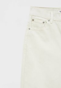 Jupe en denim couleur crème clair avec une taille mi-haute, des poches avant et des accents de ferrures argentées. Texture lisse et tissage diagonal subtil.