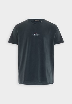 Camiseta de manga corta de color gris oscuro con cuello redondo, con un pequeño logo central de ojo y el texto "KAOTIKO SOCIETY" debajo del cuello.
