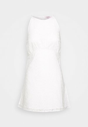 Robe blanche sans manches avec un corsage ajusté et une jupe évasée. Fabriquée en tissu texturé avec des motifs floraux et des détails en œillets au niveau de l'ourlet.