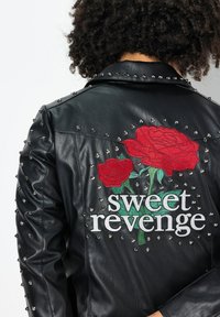 Black leather jacket with silver studs and red rose embroidery. Features the text "sweet revenge" in white. Textured and fitted design.