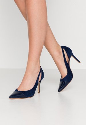 Marineblauwe hoge hakken met een puntige neus en een glanzende lakaccent. Gemaakt van suède met een slingback ontwerp.