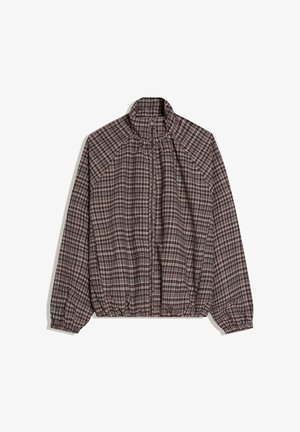 Jachetă cu fermoar în carouri maro și alb, cu guler ridicat, mâneci lungi, manșete și tiv elastice, așezată pe o suprafață albă.