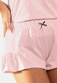 Rosa Baumwoll-Loungeshorts mit schwarzen Punkten, gerafftem Saum, elastischem Bund und einem kleinen schwarzen Schleifenakzent auf der Vorderseite.