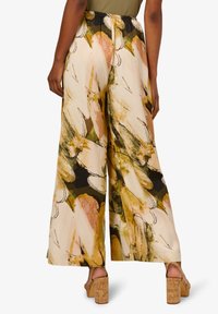 Široké kalhoty s květinovým potiskem v odstínech béžové, zelené a růžové. Lehká tkanina, elastický pas a boční detaily.