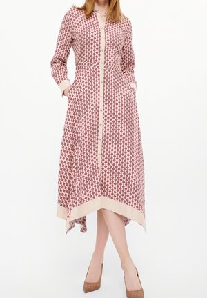 Vestido de manga larga con un patrón geométrico en rojo y crema, cierre frontal con botones y bolsillos laterales, con puños y dobladillo en contraste.