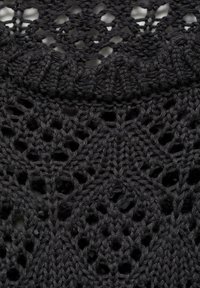 Schwarzer Strickstoff mit einem komplizierten Durchbruchs-Muster, das verschiedene geometrische Formen und eine strukturierte Oberfläche aufweist.