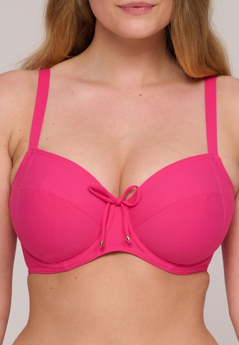 Rosa vadderad bh med justerbara band, som har en framtill placerad rosett och guldfärgade accenter, slät textur och en strukturerad underwire-design.