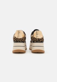 Baskets à imprimé léopard avec accents métalliques dorés, semelle plateforme épaisse et finition texturée. Comprend des détails noirs et une semelle extérieure en caoutchouc.