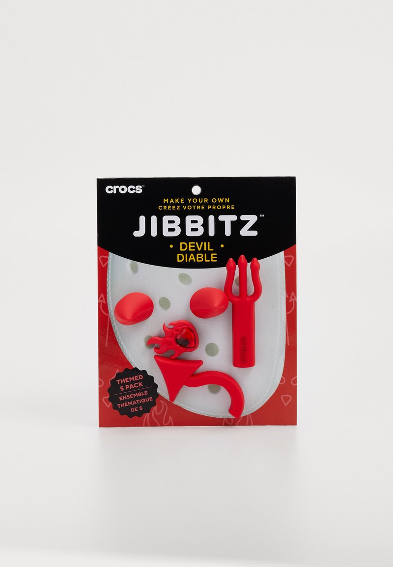 Rote Gummi-Jibbitz-Anhänger in einem Pack, einschließlich einer Gabel, Flamme, Kreis- und Pfeilformen, auf einer rot-schwarzen Rückwandkarte präsentiert.