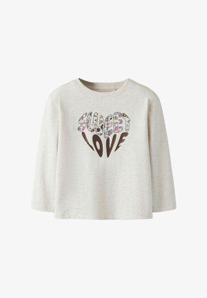 Light beige long-sleeve shirt made of soft fabric, featuring "SWEET LOVE" in colorful floral patterns with a brown heart shape below the text.