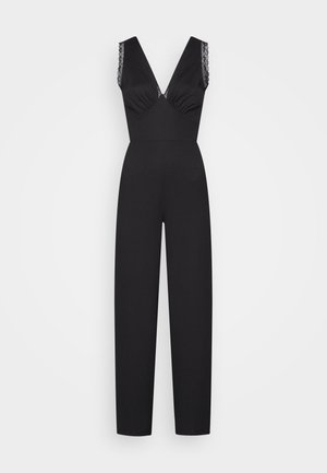 Black jumpsuit with a deep V-neck, lace trim on the straps, and wide, straight legs; crafted from a textured fabric.