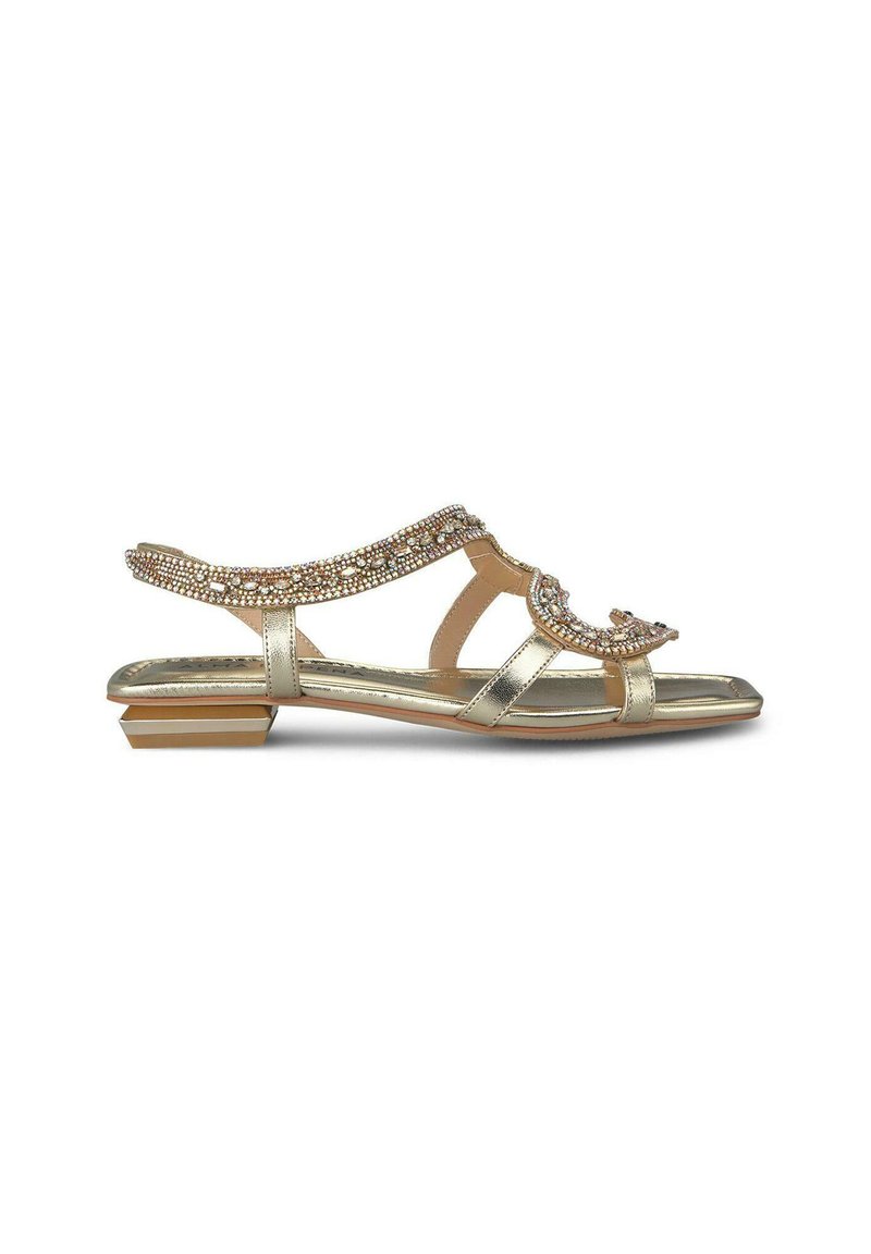 Sandalia plana de oro con punta abierta, correas decoradas con strass transparentes, plantilla acolchada y un tacón bajo.
