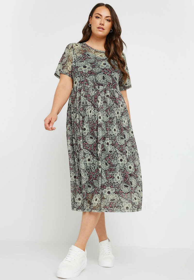 Maxime dressi, jossa on kukkakuosi ja lyhyet hihat. Ominaisuuksiin kuuluu pyöreä pääntie, liehuva siluetti sekä vihreän, violetti ja valkoisen värin sekoitus.