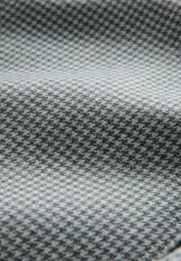 Textured fabric in grey tones featuring a geometric pattern, with a smooth surface and slight sheen, creating visual depth and dimension.