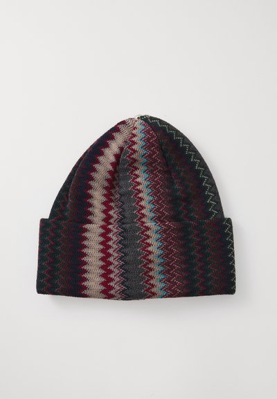 Strikket beanie med foldet skygge, der har flerfarvede zigzag-striber i burgunder, beige, grå, sort og lys blå på hvid baggrund.
