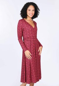 Langärmliges Kleid in Dunkelrosa mit floralem Muster, V-Ausschnitt, tailliertem Schnitt und weit ausgestellt Rock, aus dehnbarem Material gefertigt.