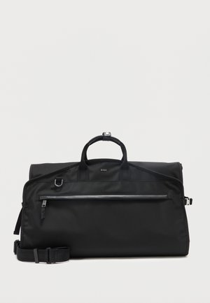 Czarna torba BOSS typu duffel z górnymi uchwytami, przednią kieszenią na zamek, regulowanym paskiem na ramię oraz srebrnymi okuciami na białym tle.