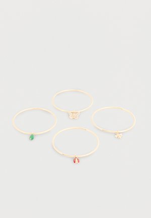 Quatre bracelets fins en or avec de petits charms suspendus : une goutte verte, un papillon avec des pierres claires, une coccinelle rouge et une abeille en or.