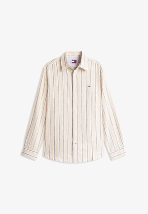 Beige langermet skjorte med knapper, med tynne, vertikale svarte og hvite striper og en liten rektangulær logo i rød, hvit og blå på brystet.