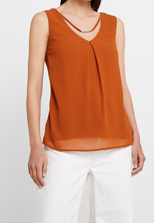 Blusa senza maniche color ruggine con scollatura a V, caratterizzata da un davanti drappeggiato e sottili spalline con un'accenno metallico. Tessuto liscio e leggero.