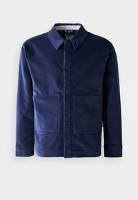 Navy blue corduroy jacket with a button-up front, a pointed collar, and two large front pockets. Smooth texture and tailored fit.