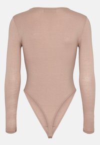 Pitkähihainen body, joka on valmistettu pehmeästä, nudenvärisestä kankaasta. Siinä on kaarroke selkä ja thong-leikkaus, sekä sileä, kohtalaisen joustava pinta. Ei näkyvää metalliosaa.