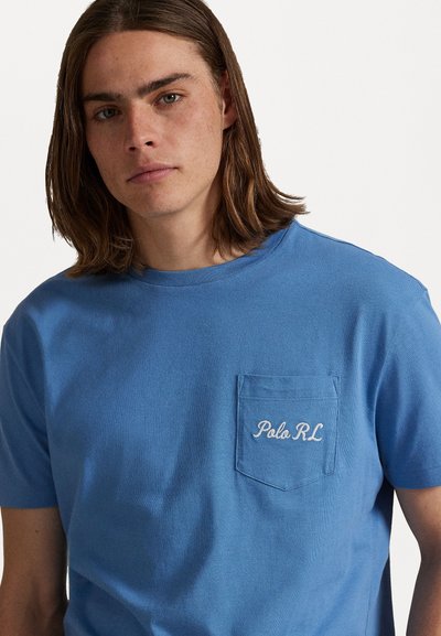 Tricou din bumbac albastru, cu mâneci scurte, guler rotund și un buzunar frontal cu textul brodat alb "Polo RL".