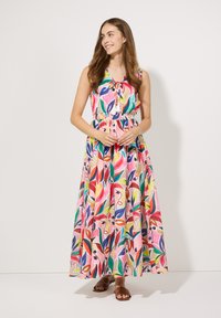 Maxikleid mit einem bunten Blättermuster, das einen lässigen Schnitt, ärmelloses Design und eine taillierte Taille aufweist. Das Material scheint leicht und atmungsaktiv zu sein.