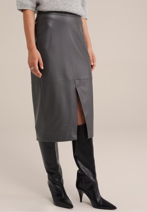 Szara skórzana spódnica ołówkowa z przednim rozcięciem, o gładkiej fakturze i dopasowanym kroju. Zestawiona z wysokimi czarnymi botkami na szpilce.