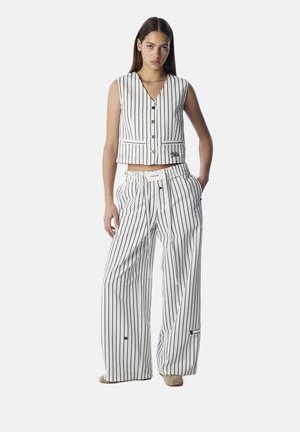 White and navy striped crop vest with buttons, paired with wide-leg pants featuring an elastic waistband and side pockets.