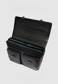 Zwarte leren tas met twee voorvakken met rits, binnenvakken en een klepsluiting. Soepele textuur met metalen accenten.