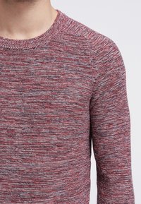 Gebreide trui in rode en grijze tinten, met een ronde halslijn, een gestructureerd patroon en lange mouwen met een getailleerde pasvorm.