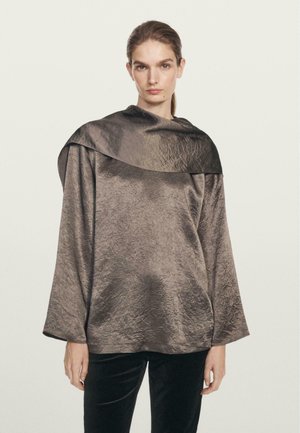 Metallic bronze top med en bred, draperet krave og lange ærmer. Det strukturerede stof har et let krøllet udseende.