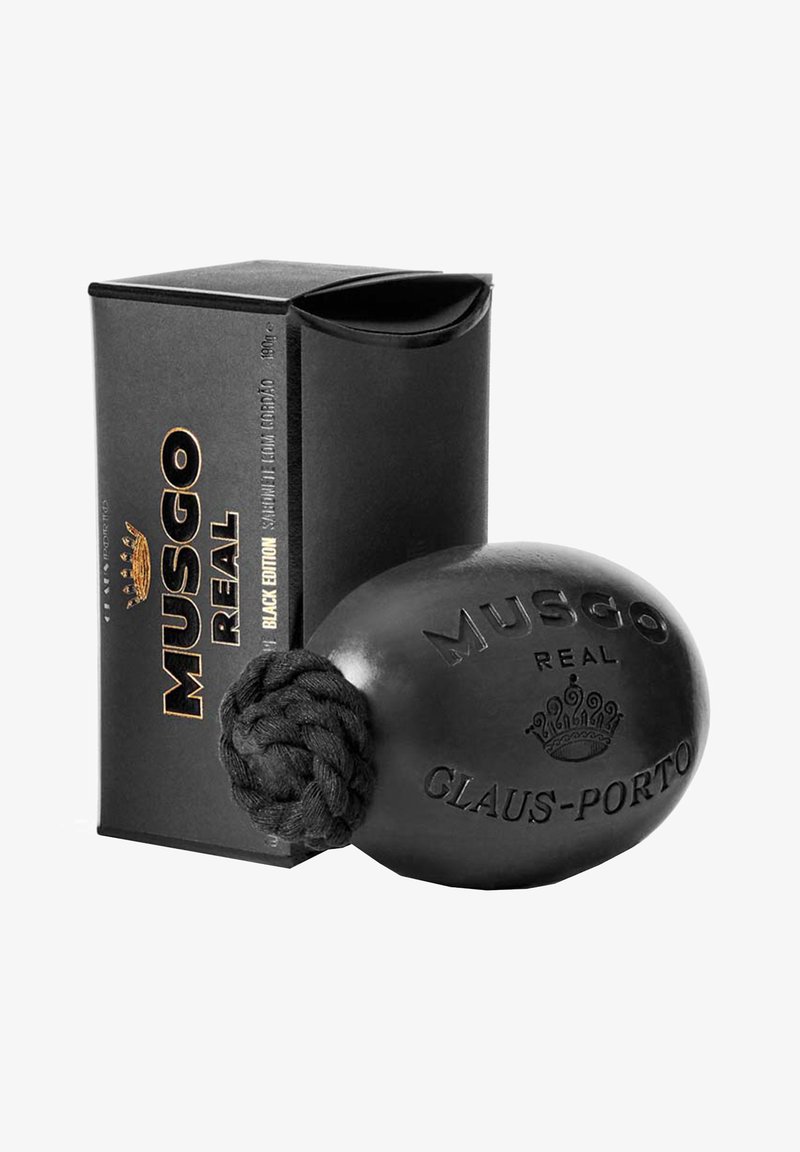 Schwarze Rasierseife in runder Form, mit einem geflochtenen Griff, geprägt mit "MUSGO REAL" und "GLAUS-PORTO". Verpackung in schwarzer Box.