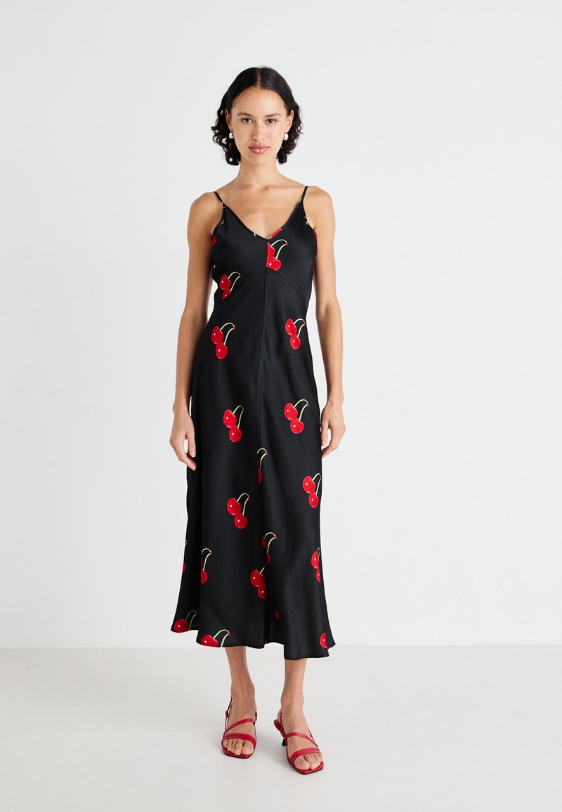 Svart satin midi-kjole med kirsebærmotiv, V-hals, tynne stropper og utsvingt kant. Kombinert med røde sandaler med remmer.