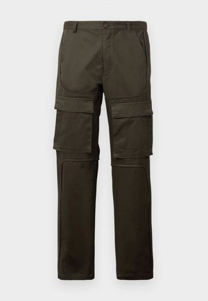 Tumedat oliivrohelised cargo-püksid mitme suure esikoti ja reie taskuga, nööbiga kinni pandud ning õmmeldud põlvetaskudega valge taustal.