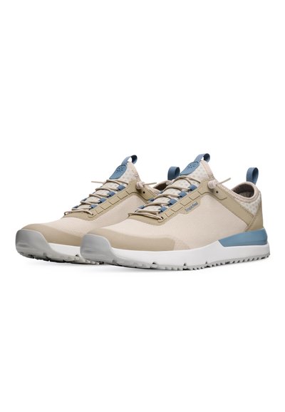 Beige athletic shoes with mesh upper, blue accents, laces, and loop. Textured collar, padded insole, and white rubber sole with grip pattern.