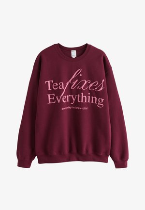 Burgundy sweatshirt with pink text saying "Tea fixes Everything" and "every day is brew-tiful" in casual font.