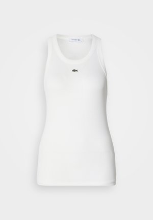White sleeveless tank top with a round neckline and ribbed texture. Features a small green Lacoste crocodile logo on the chest.