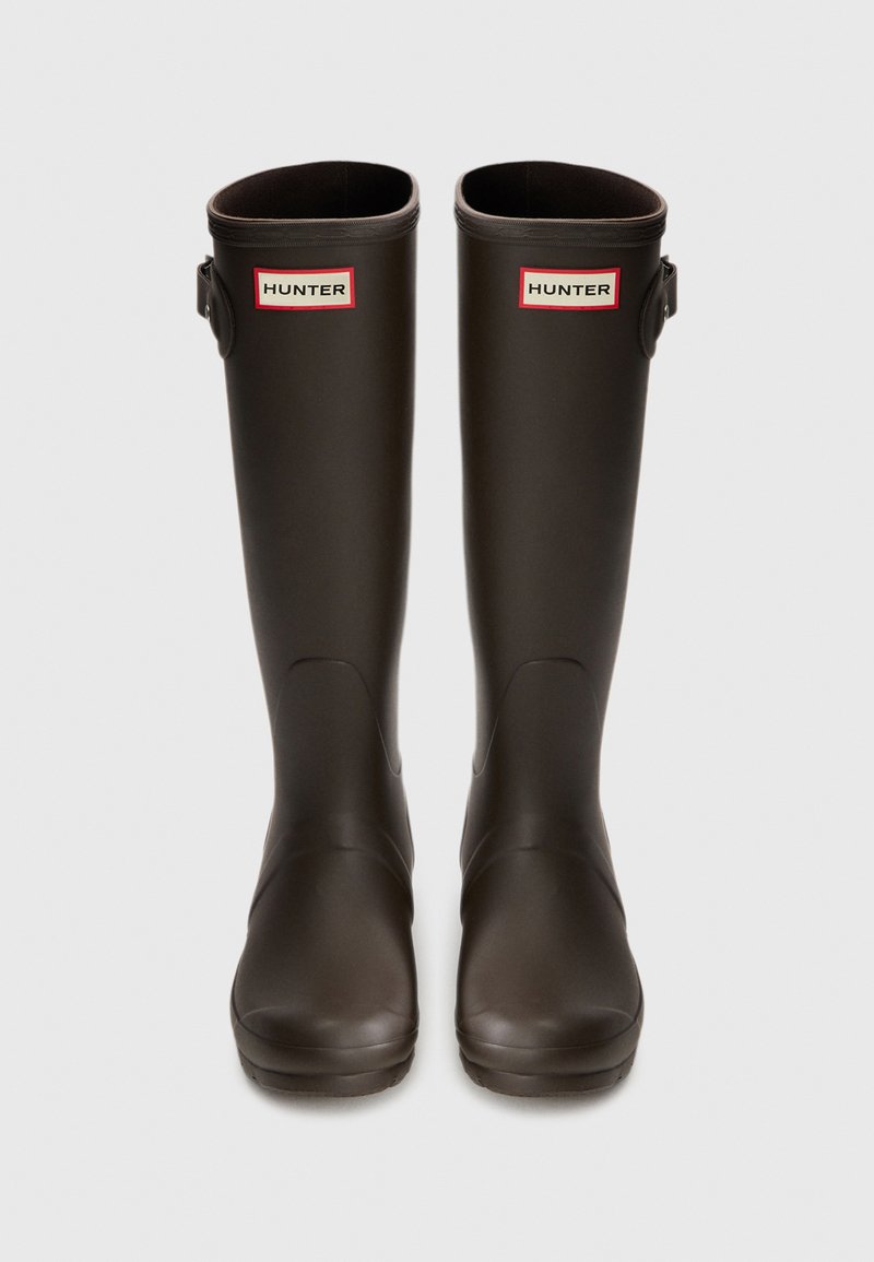 Hohe, matte, schwarze Gummi-Regenstiefel mit verstellbarem Riemen an der Seite und weißem rechteckigem "HUNTER"-Logo nahe der oberen Front.