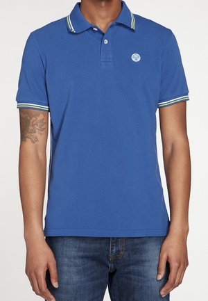 Blauwe polo van katoen, met een klassieke kraag en groene en witte gestreepte accenten, en een klein logo op de borst.