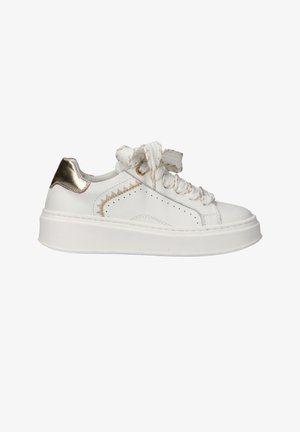 Witte lage sneaker met dikke zool, metalen gouden hielstuk, zigzag gouden stikseldetail en dikke witte veters gestrikt in een strik.
