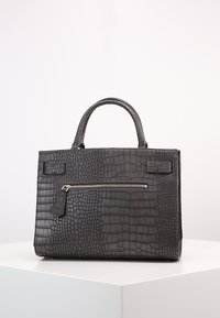 Czarna torebka skórzana w wzór krokodylej skóry z górnym uchwytem i poziomą kieszenią z suwakami z przodu, wyeksponowana na białej powierzchni.