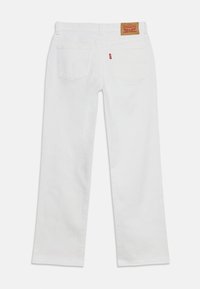 Άσπρο τζιν Levi's, εμφανισμένο από πίσω με δύο πίσω τσέπες, θηλιές για ζώνη και ένα καφέ δερμάτινο ετικέτα του brand στη μέση.