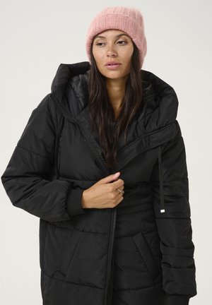 Black puffer coat with a hood, featuring a zip closure, elastic cuffs, and a quilted texture. Paired with a pink knitted beanie.