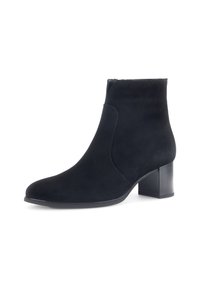 Botas de tobillo de ante negro con puntera redondeada y un tacón cuadrado de 7,5 cm. Presentan detalles laterales y una textura suave, adecuadas para diversos conjuntos.