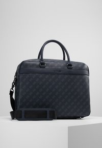 Sac en cuir texturé bleu foncé avec deux poignées supérieures et une bandoulière amovible, présentant un design de logo à motif et une finition lisse.