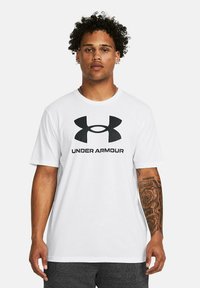 Witte katoen t-shirt met een grote zwarte Under Armour-logo en tekst in het midden, korte mouwen en een comfortabele pasvorm.