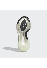 Suola della scarpa con un design testurizzato bianco e nero, caratterizzata da una silhouette pulita e liscia e da modelli di battistrada distintivi per la trazione.